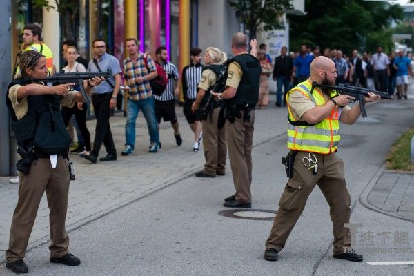 7月22日，德国慕尼黑奥林匹亚购物中心传枪声，据悉十几人丧生。图为警察保护着人们撤出购物中心。(Joerg Koch/Getty Images)